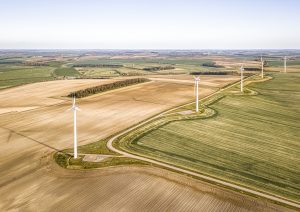 take-the-aerial-of-the-turbines-and-the-hermosous-green-fields-about-the-sharp-oranges
